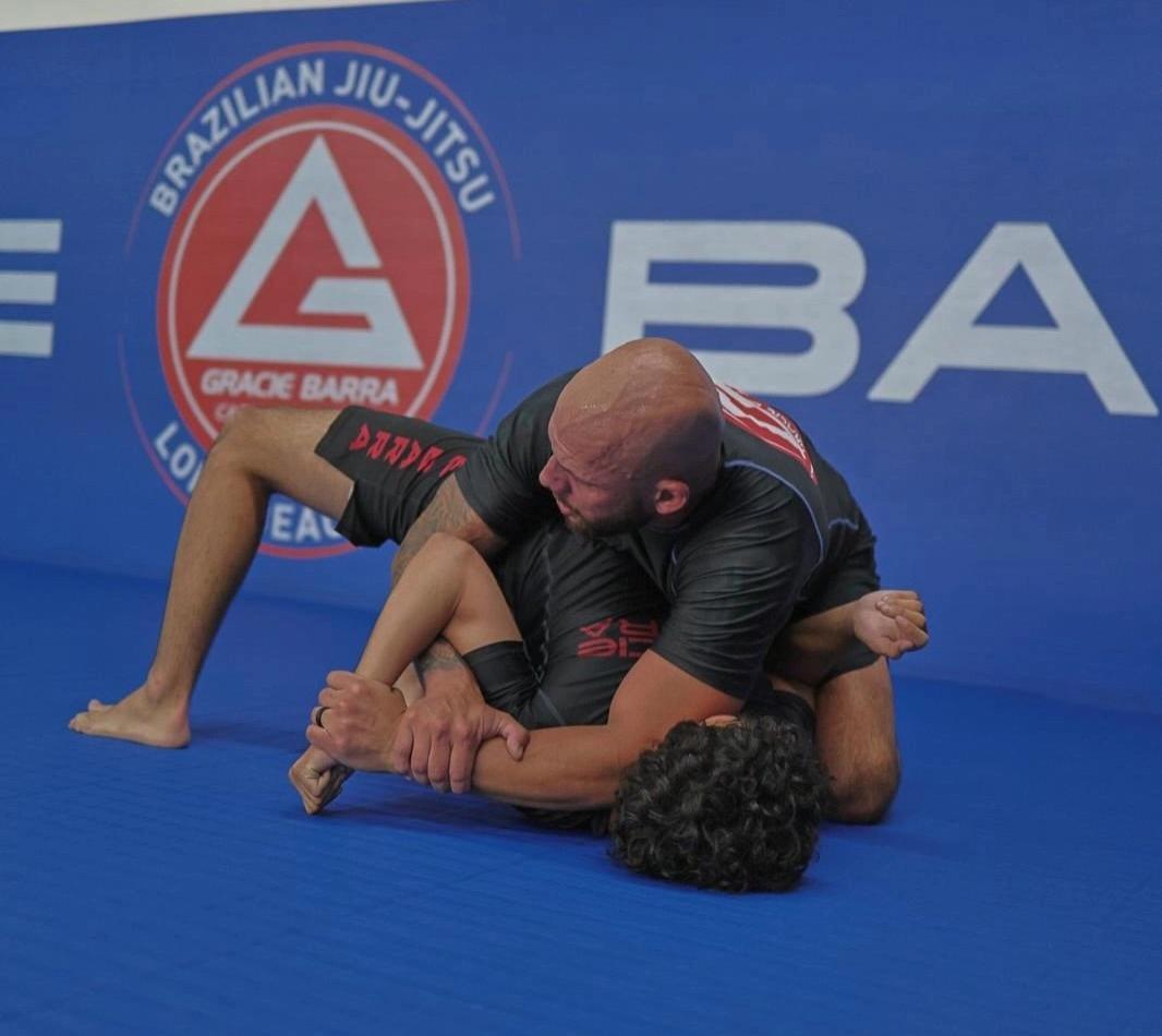 Gracie Barra Long Beach, CA - Jiu-Jitsu & Self-Defense 15 Professor tying a new belt on a student during a promotion
