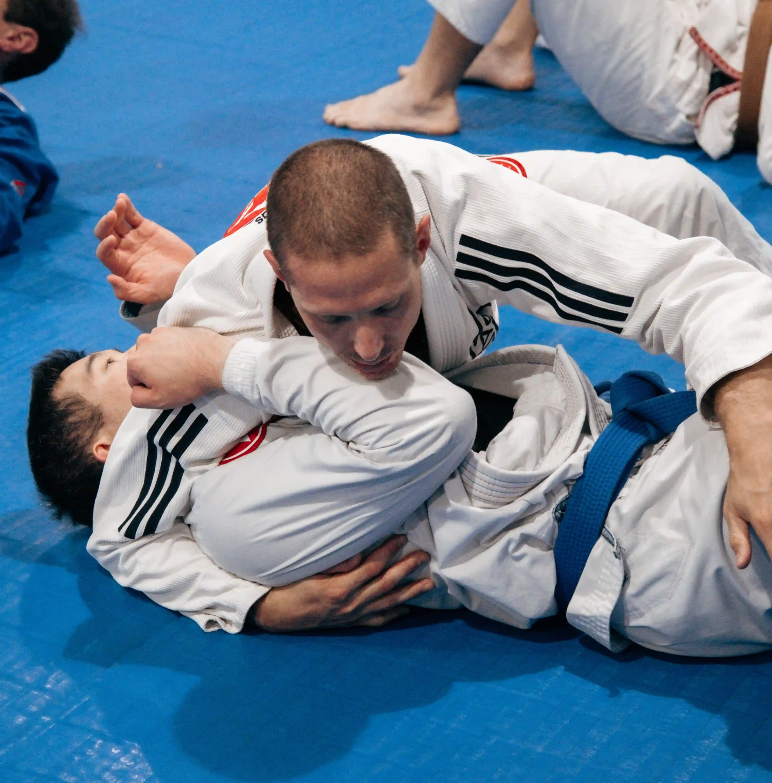 Students practicing ground control in Gracie Barra uniforms